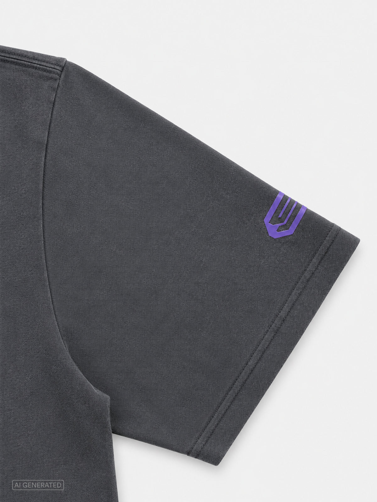 Detailaufnahme des rechten Ärmels eines dunkelgrauen T-Shirts. Nahe dem Ärmelabschluss befindet sich ein violettes Stone-Techno-Logo als kontrastierendes Designelement.